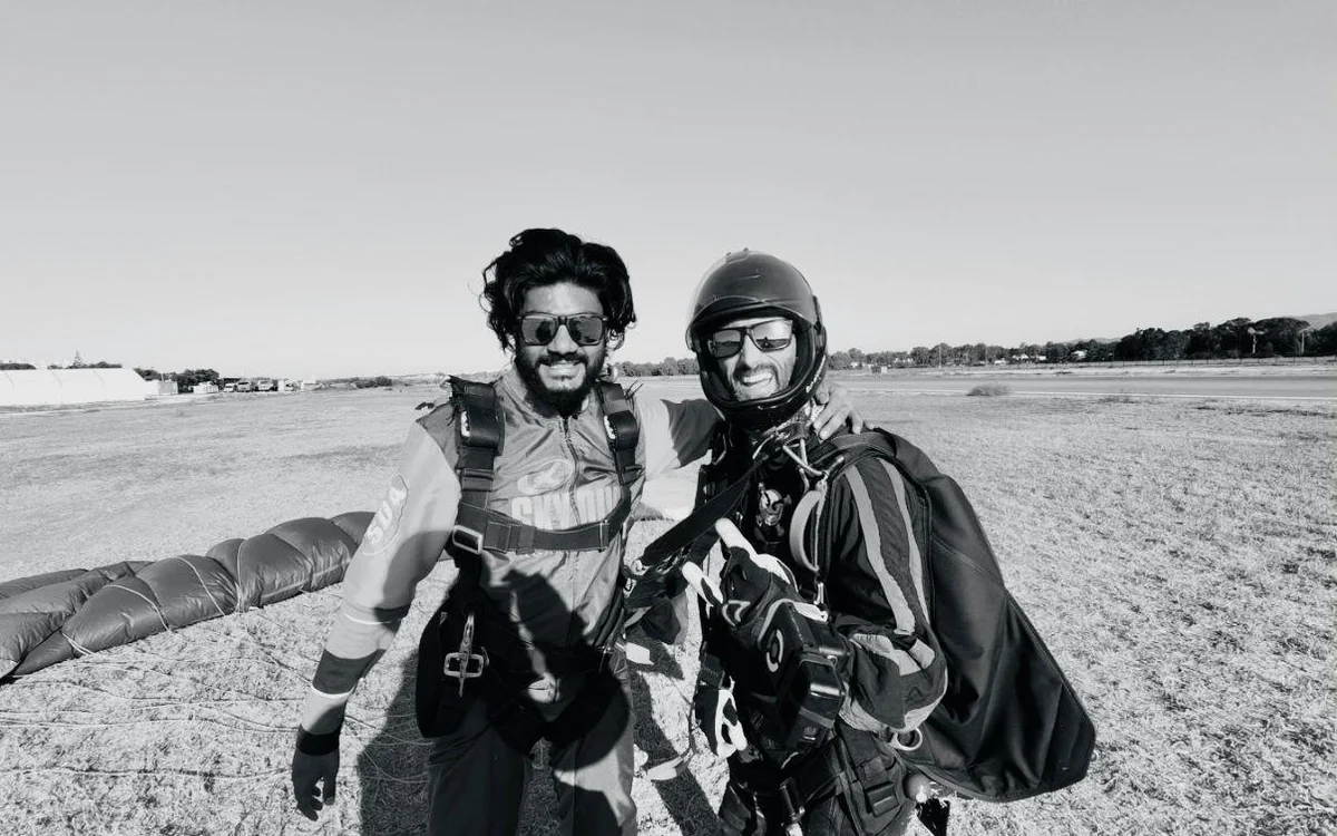 Two people standing together after landing, photographed in black and white