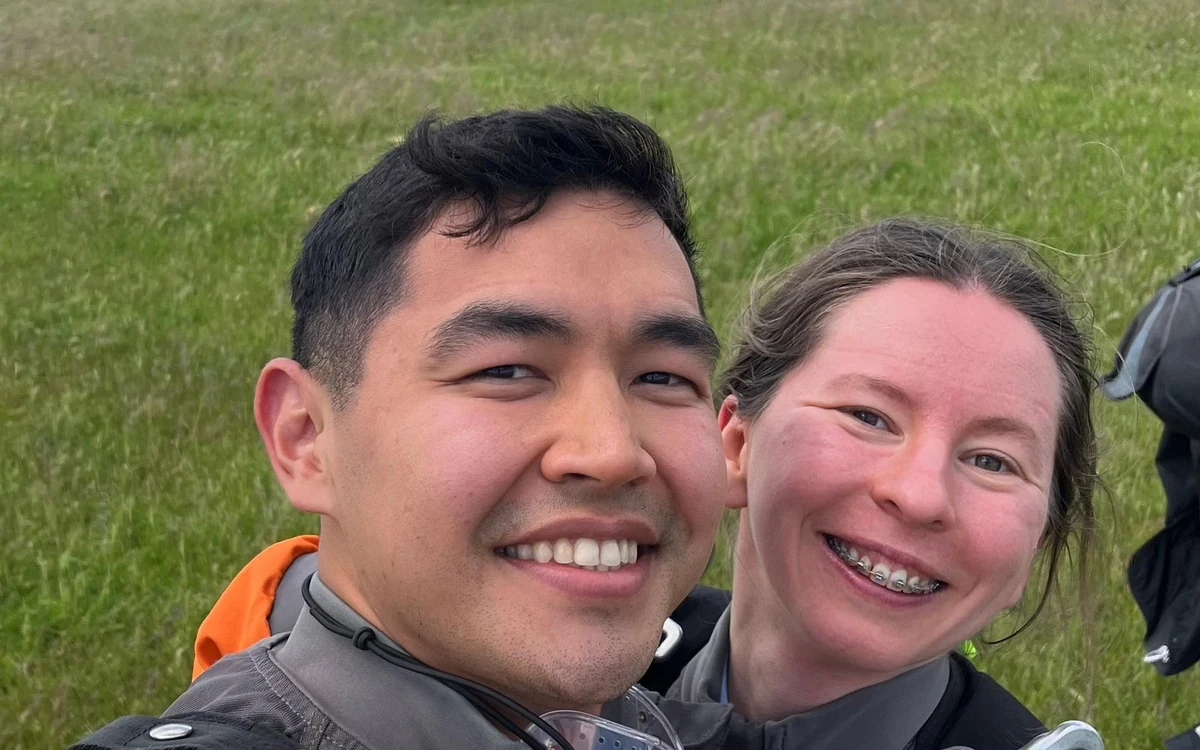 An instructor and a tandem jumper close up in freefall, both grinning