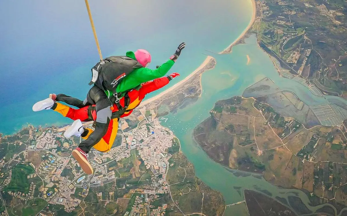 An open canopy high above the Alvor estuary, the jumper small against the water