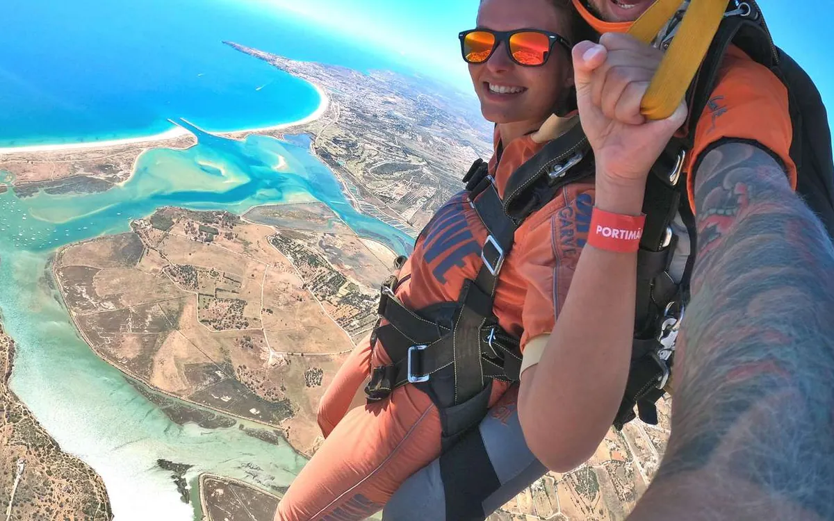 A tandem selfie above a sandbar and turquoise shallow water
